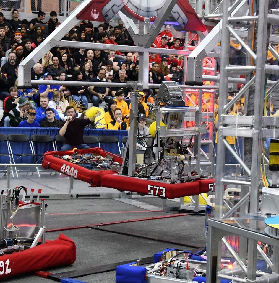Robots competing in a robotics tournament with an audience watching